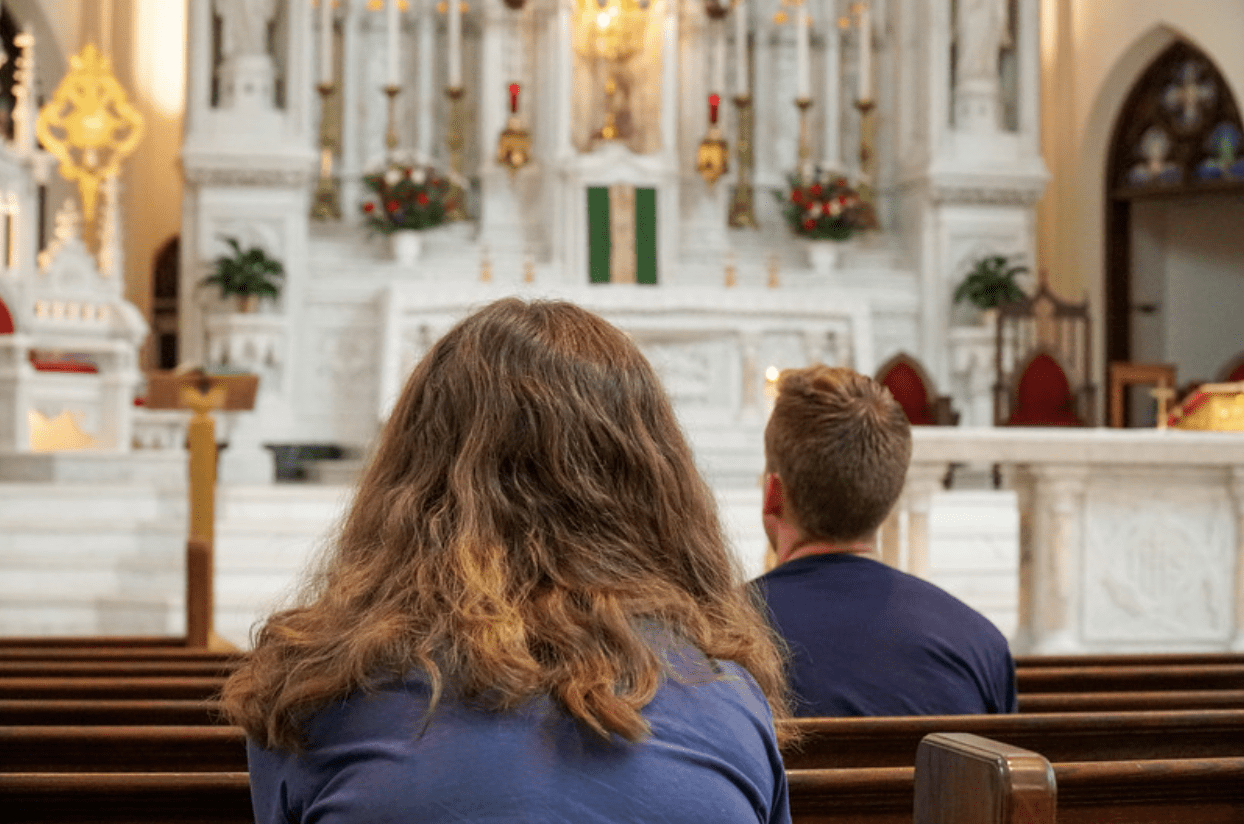 A woman prays her confession penance after going to confession. 